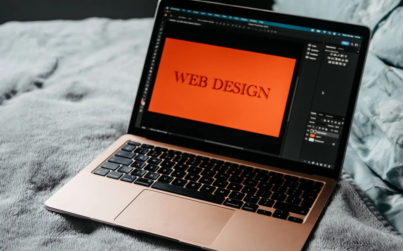 Laptop open to web design software in a creative workspace